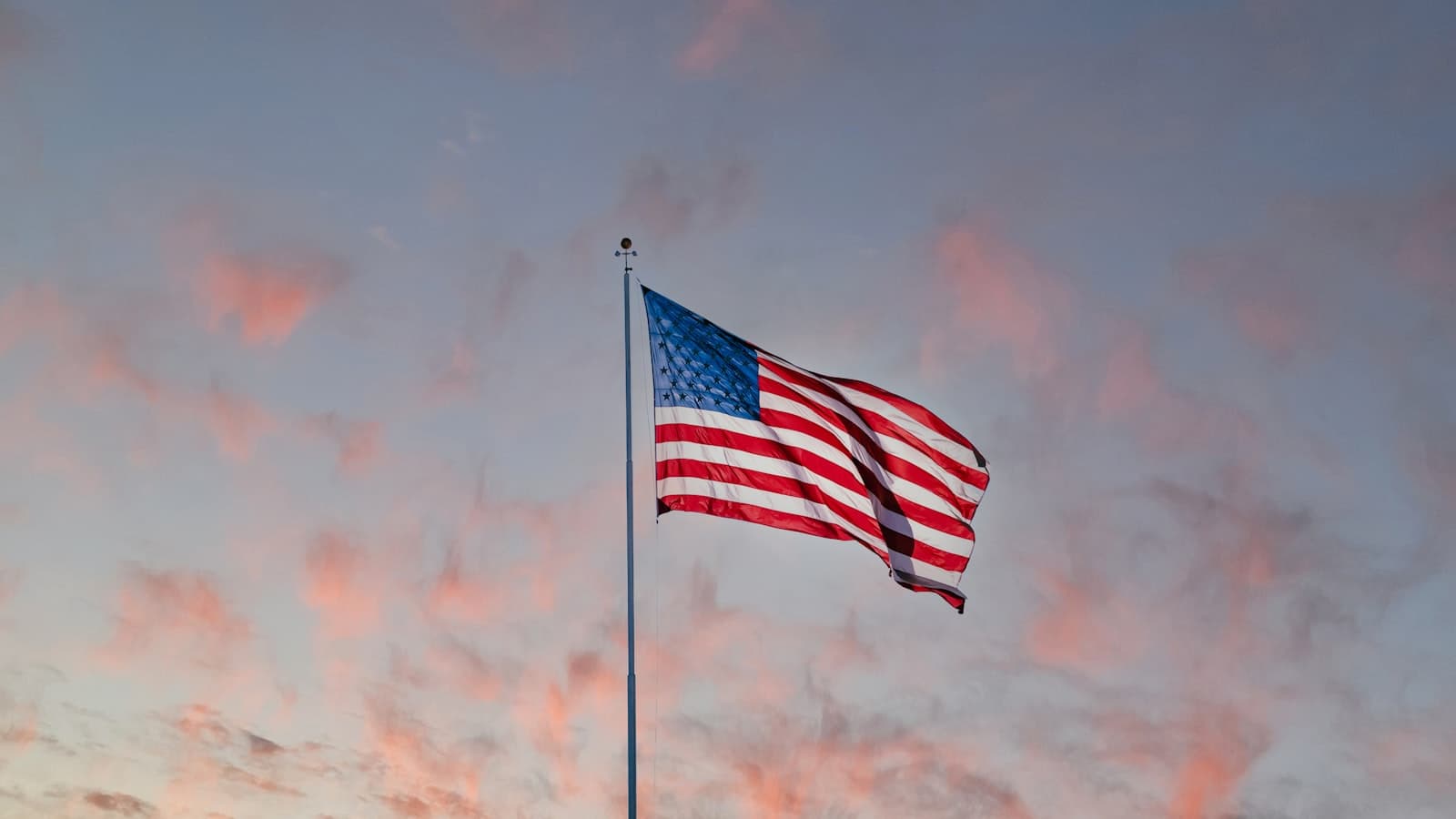 American flag on a pole against a cloudy sky